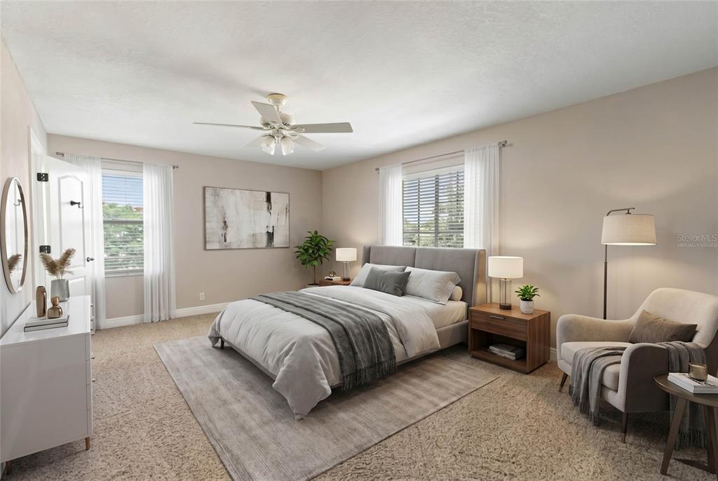 A bedroom features a bed, a ceiling fan, a chair, and a dresser on carpet — 4306 BARRACUDA DRIVE, BRADENTON, FL