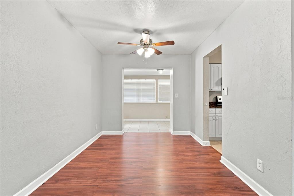 A dining room with wood-look flooring, a ceiling fan, and a doorway to the kitchen — 3519 CALUMET DRIVE, ORLANDO, FL