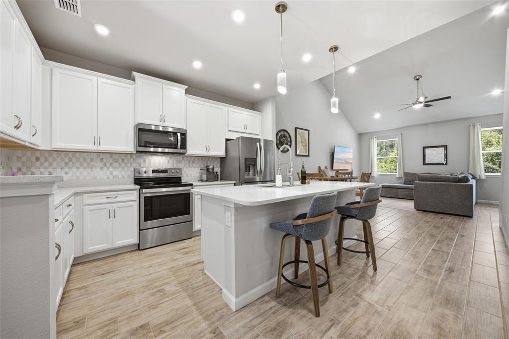 A two-story townhouse with a beige stucco exterior, a two-car garage, and palm trees — 5636 SILVERBRIDGE TRAIL, BRADENTON, FL