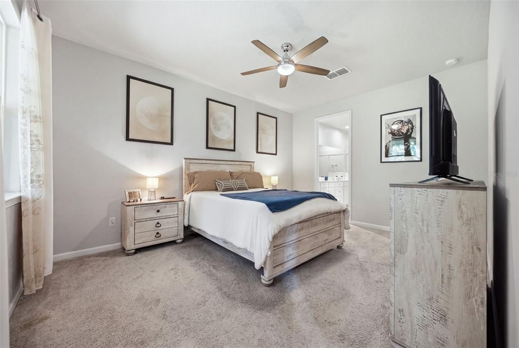 A living room features a grey sectional sofa, vaulted ceilings, tile flooring, and a ceiling fan — 5636 SILVERBRIDGE TRAIL, BRADENTON, FL