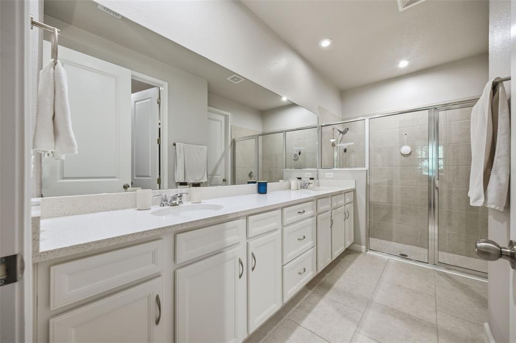 A bedroom features a wooden bed frame, matching nightstand, dresser with a television, and ceiling fan — 5636 SILVERBRIDGE TRAIL, BRADENTON, FL