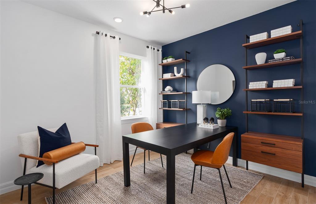 A home office features a dark blue accent wall, two shelving units, and a black desk — 2222 BRANCHED OAK ROAD, ST CLOUD, FL