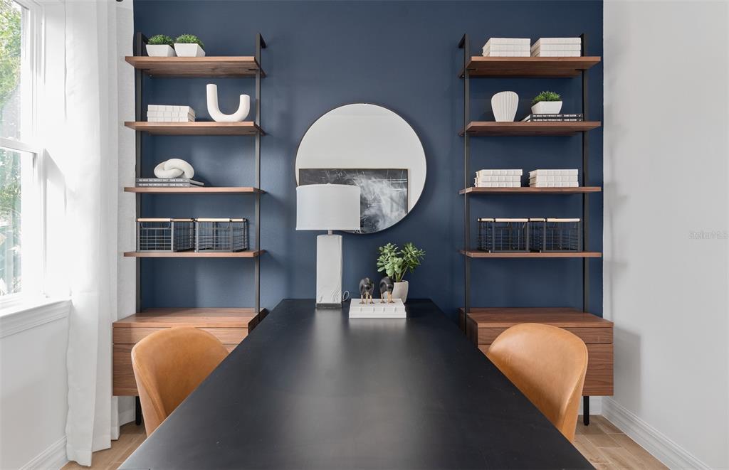 A home office features a black desk, two leather chairs, and symmetrical shelving against a blue wall — 2222 BRANCHED OAK ROAD, ST CLOUD, FL