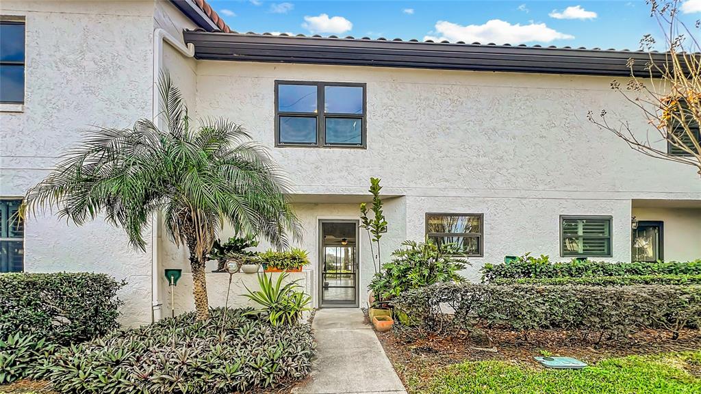 The exterior of a two-story stucco building features a palm tree and a front walkway — 630 KILLARNEY BAY COURT UNIT 3, WINTER PARK, FL