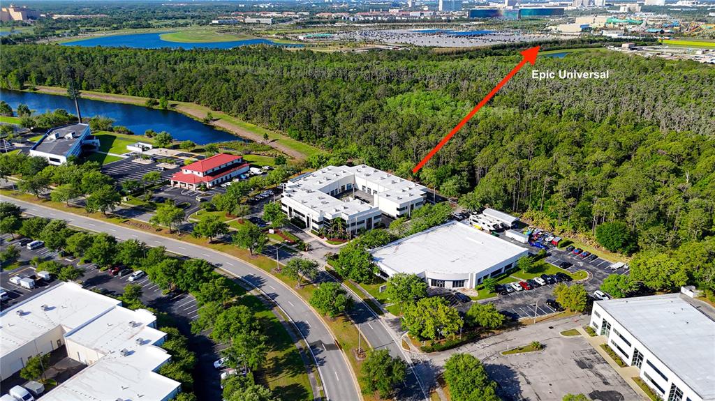 An aerial view shows commercial office buildings, parking lots, and a wooded area near water — 8615 COMMODITY CIRCLE UNIT 2, ORLANDO, FL