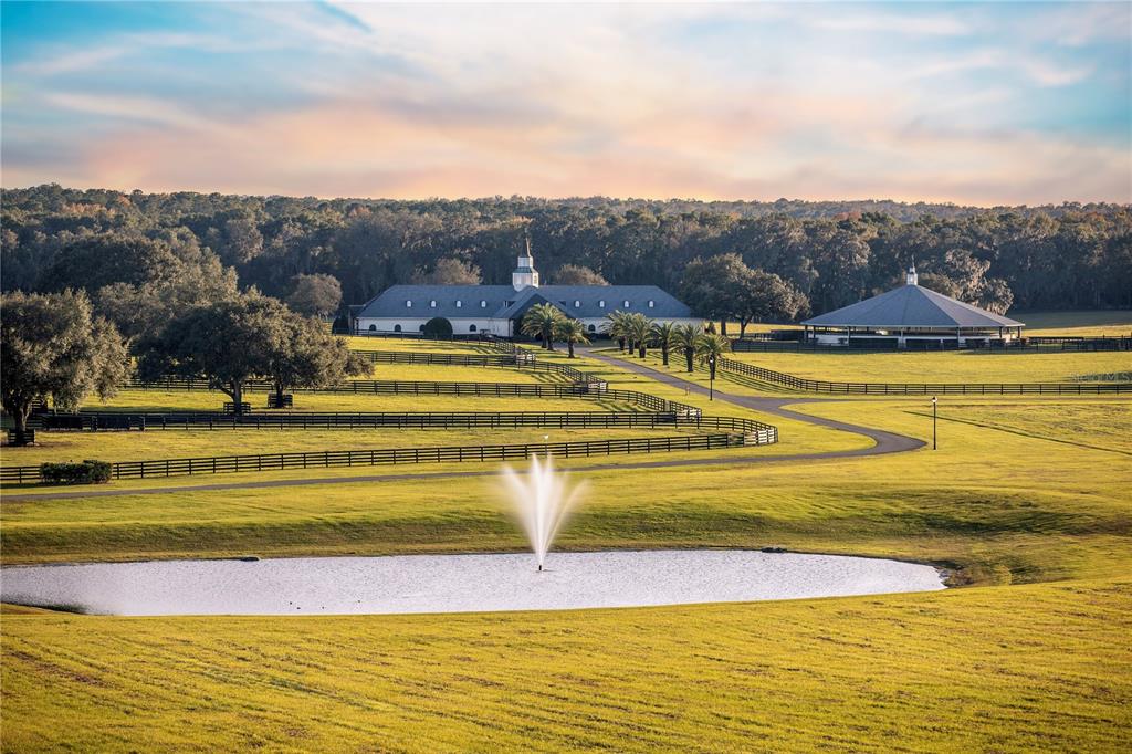 An aerial view shows a large house surrounded by expansive green pastures and scattered trees — 6800 SE 193RD STREET, MICANOPY, FL