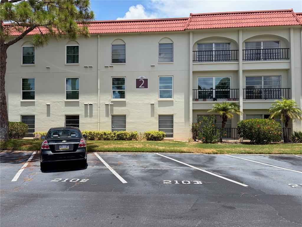 A sign for Mediterranean Manors 2700 is mounted on a beige fence in front of a building — 2700 BAYSHORE BOULEVARD UNIT 2108, DUNEDIN, FL