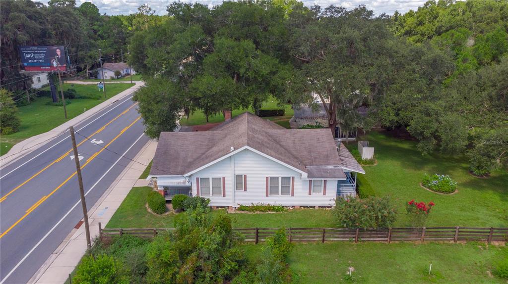 An aerial view of a white, single-story house with a brown roof located near a road — 3778 E C-466 ROAD, OXFORD, FL