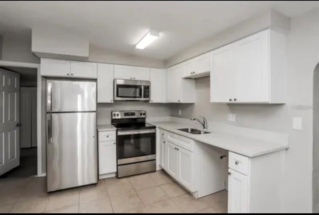 A kitchen with white cabinets, stainless steel appliances, and light-colored countertops — 918 VALMAR STREET, BRANDON, FL