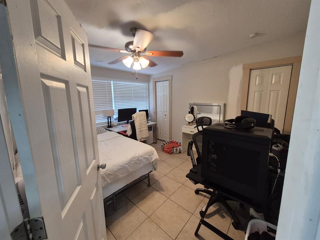 A bedroom features a bed, a computer desk, tile flooring, and a ceiling fan — 918 VALMAR STREET, BRANDON, FL