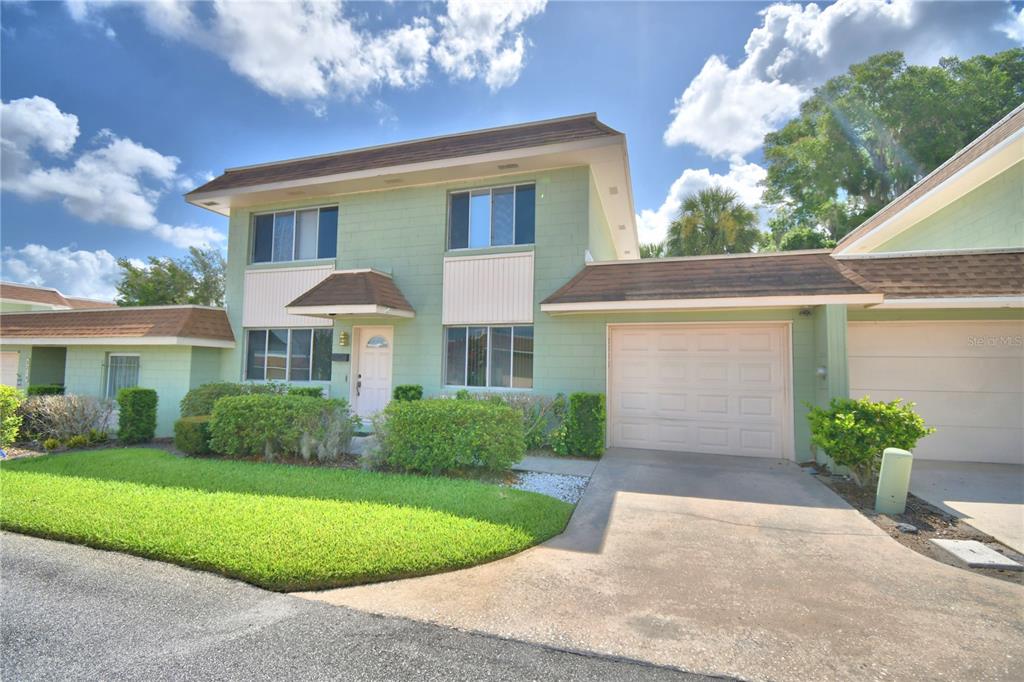 A two-story light green townhouse with a brown shingled roof and an attached garage — 2216 STARBOARD, WINTER HAVEN, FL
