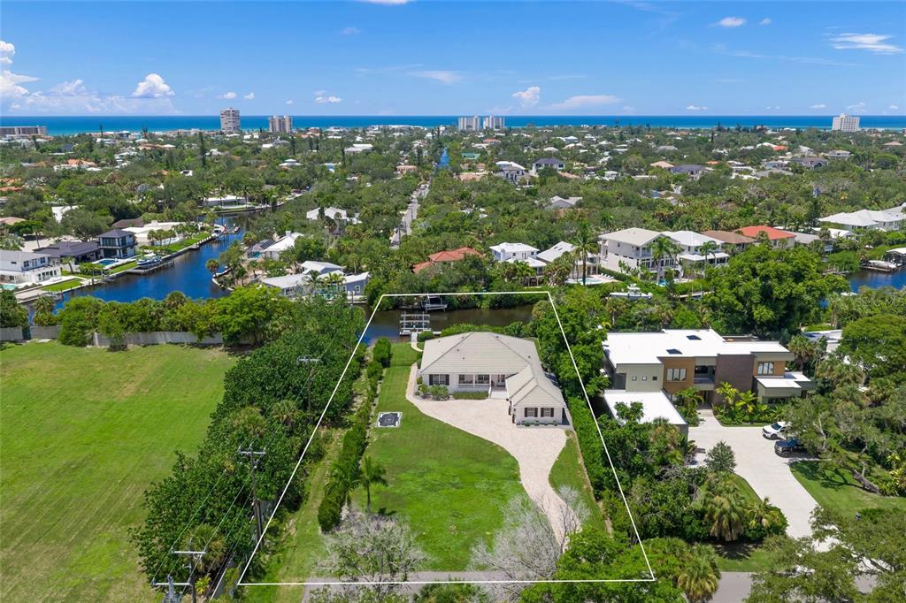 An aerial view shows a single-story house with a large yard bordering a canal — 5178 OAKMONT PLACE, SARASOTA, FL
