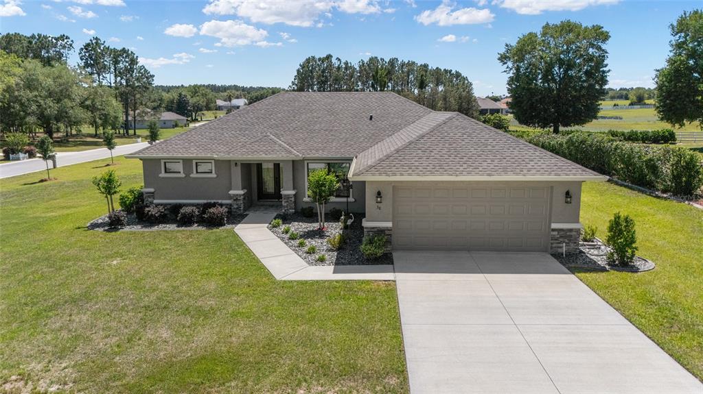 An aerial view of a single-story house with a gray exterior, shingled roof, and driveway — 38 S POLESTAR POINT, INVERNESS, FL