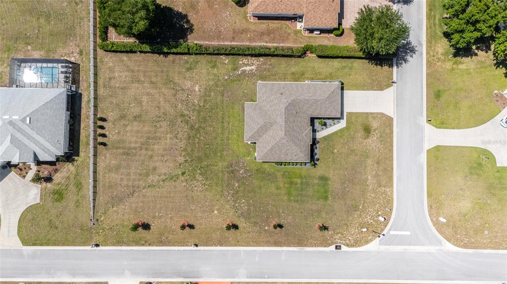 An aerial view shows a single-family home situated on a large, grassy corner lot — 38 S POLESTAR POINT, INVERNESS, FL