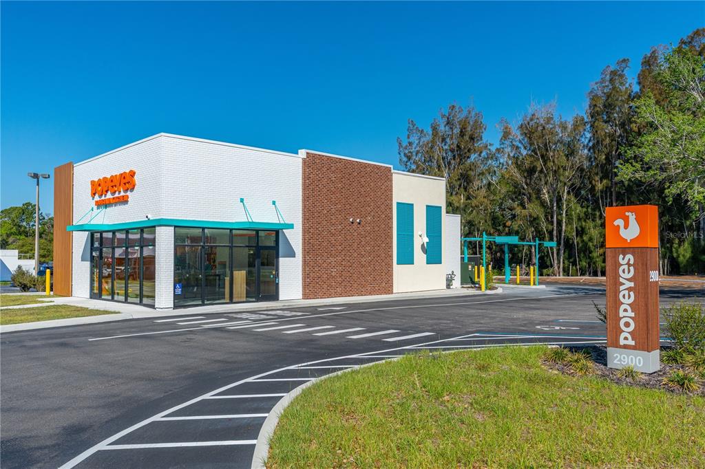 A modern Popeyes restaurant building with a brick facade and a tall roadside sign — 2900 S RIDGEWOOD AVENUE, EDGEWATER, FL