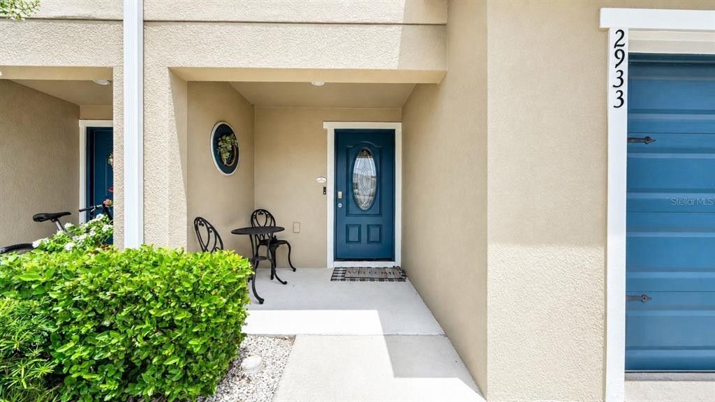 A row of two-story townhouses with beige siding, dark blue garage doors, and concrete driveways — 2933 FIELDWOOD CIRCLE, ST CLOUD, FL