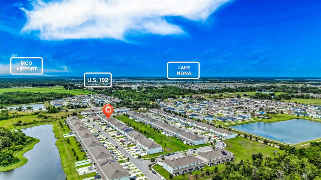 A row of two-story townhouses features blue garage doors and driveways under a cloudy sky — 2933 FIELDWOOD CIRCLE, ST CLOUD, FL