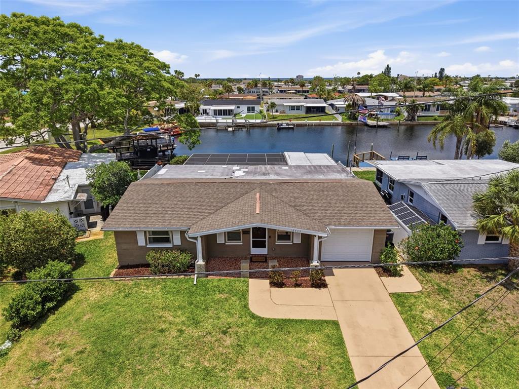 An aerial view of a single-story house with a brown roof and a waterfront backyard — 12735 1ST ISLE, HUDSON, FL