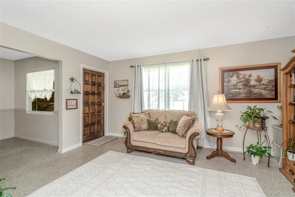A view from an interior room looking through an open doorway toward a covered porch — 12212 FLORAL LANE, THONOTOSASSA, FL