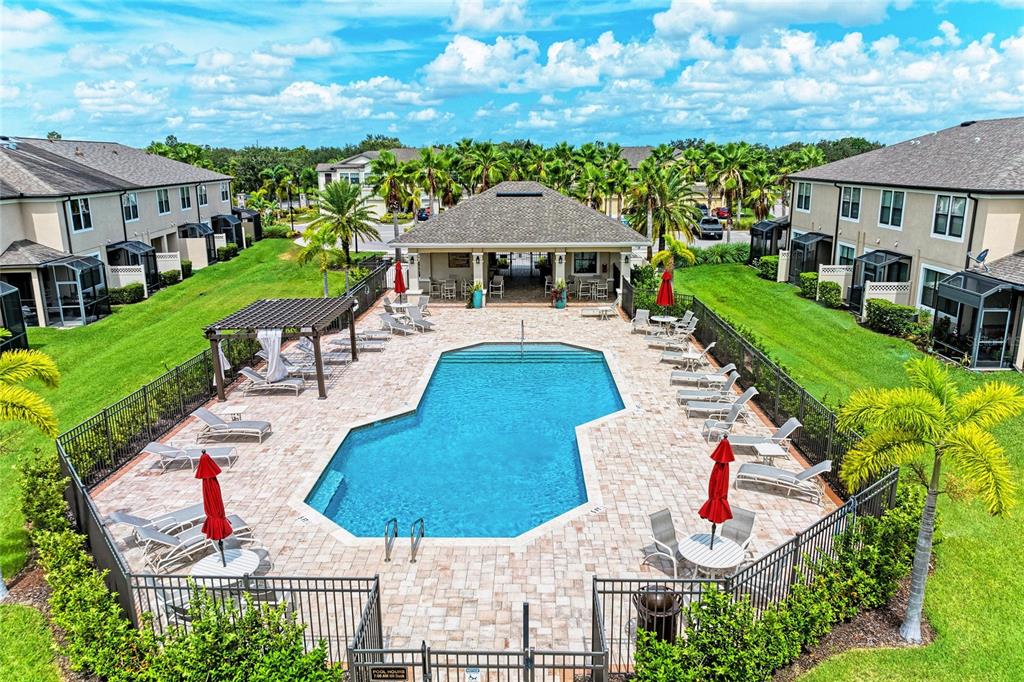 An aerial view shows a rectangular swimming pool surrounded by lounge chairs and a pavilion — 5286 78TH ST CIRCLE E, BRADENTON, FL