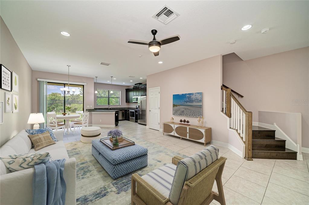 An open-concept living room and kitchen area with tile flooring and a staircase — 5286 78TH ST CIRCLE E, BRADENTON, FL