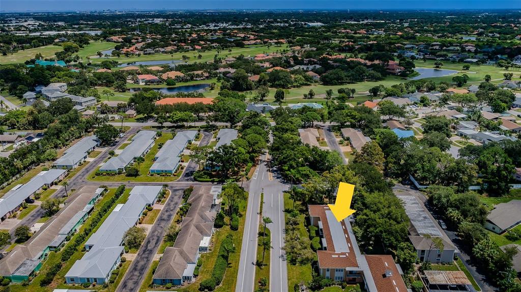 An aerial view shows a residential complex with multiple buildings, parking areas, and surrounding greenery — 8300 BARDMOOR BOULEVARD UNIT 103, SEMINOLE, FL