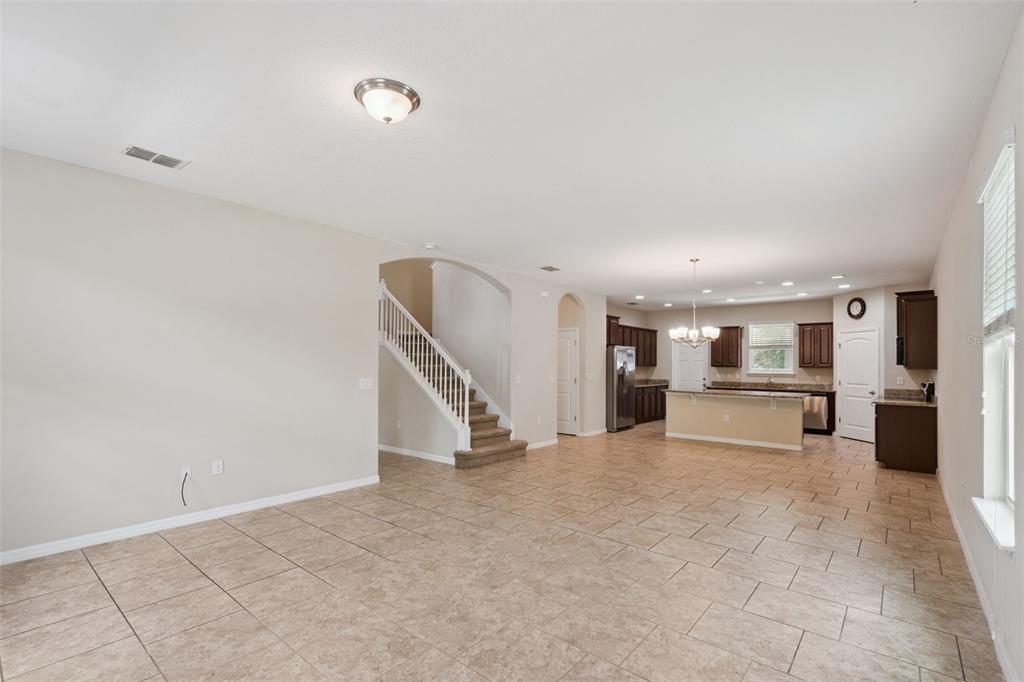 A two-story suburban house features beige siding, blue shutters, and a front hedge — 2230 J LAWSON BOULEVARD, ORLANDO, FL