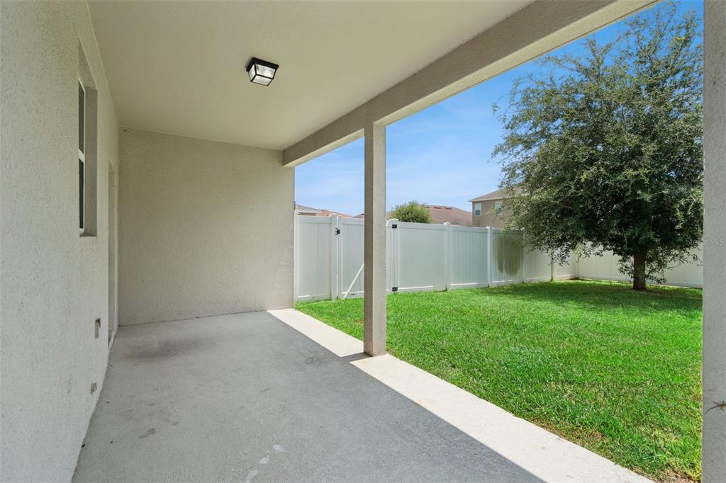 A carpeted room with two windows, beige walls, and an arched entryway to a tiled hallway — 2230 J LAWSON BOULEVARD, ORLANDO, FL