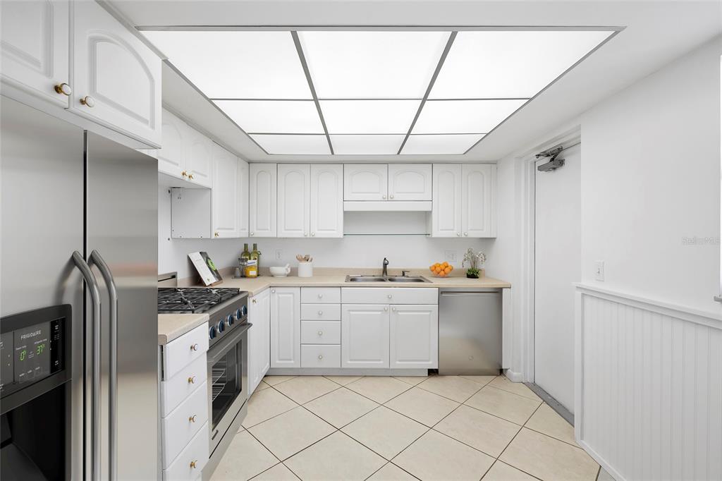 An elevator lobby with tile flooring, two metal elevator doors, and a window with seating — 5108 BRITTANY DRIVE S UNIT 903, ST PETERSBURG, FL
