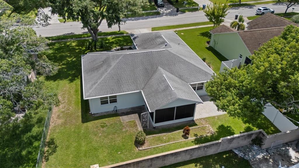 An aerial view of a single-story house with a gray shingled roof and screened porch — 7329 FAIRWOOD AVENUE, NEW PORT RICHEY, FL
