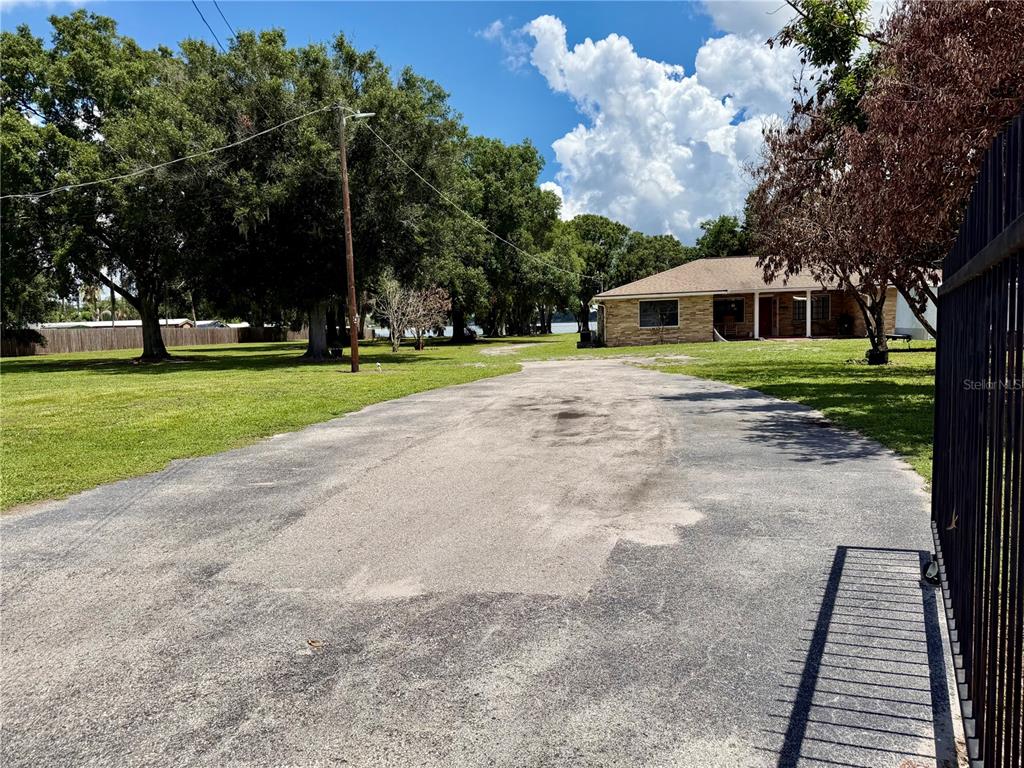 A single-story multi-unit building with a gravel parking area and a white SUV parked outside — 1702 1/2 US HIGHWAY 92 W, AUBURNDALE, FL