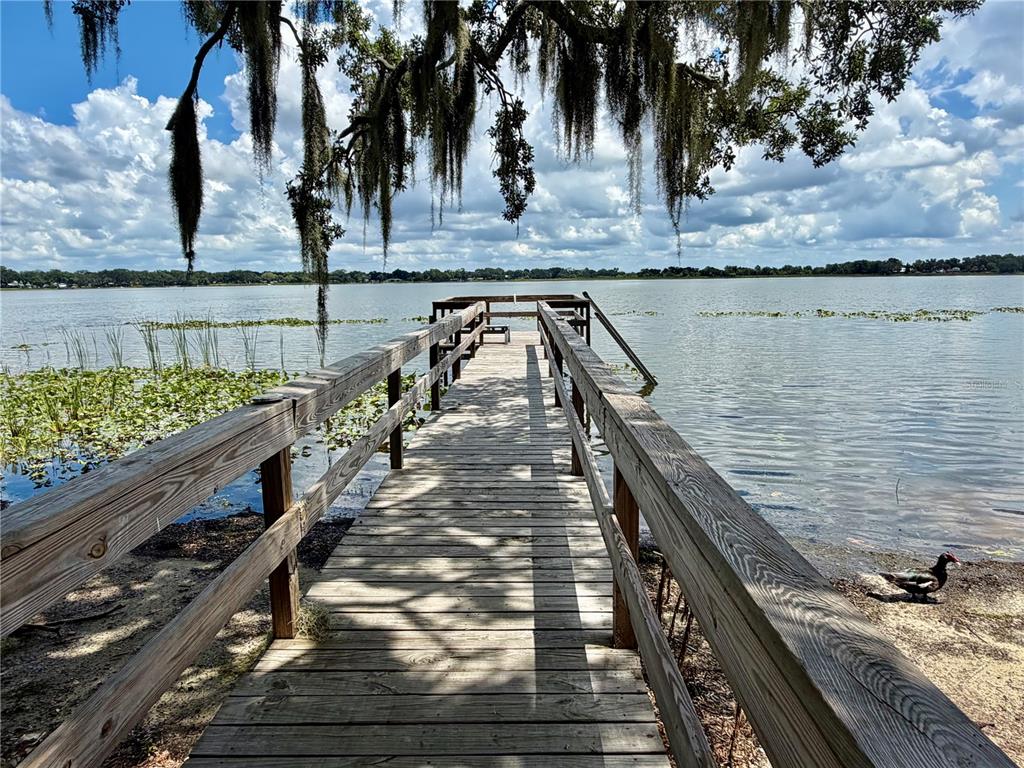 A wooden gazebo with a central bar overlooks a lake from a large deck — 1702 1/2 US HIGHWAY 92 W, AUBURNDALE, FL