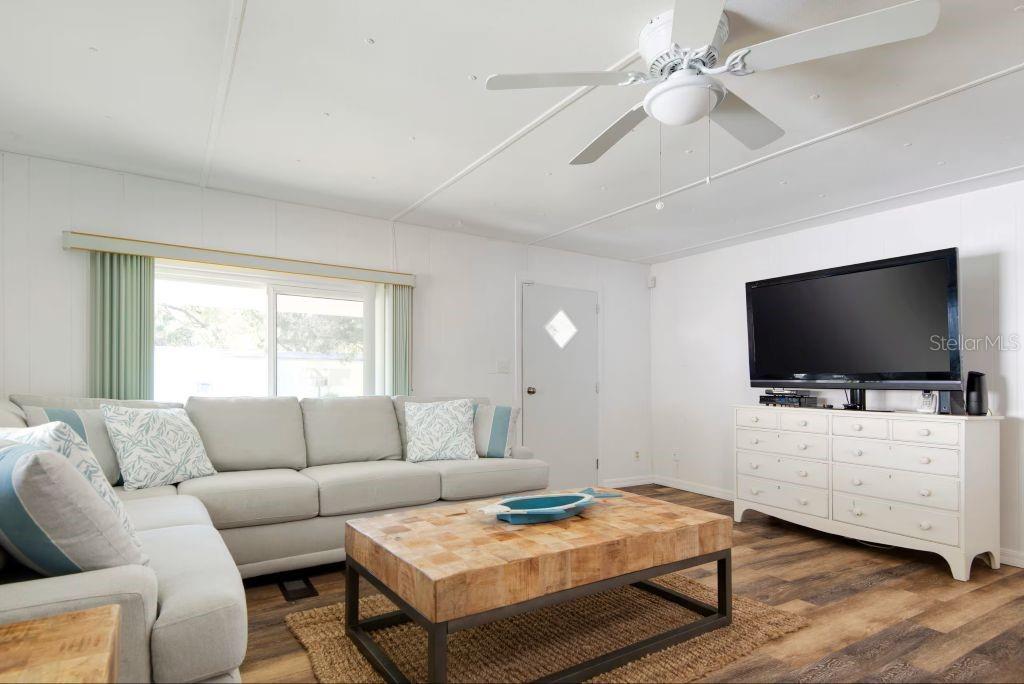 A living room features a light gray sectional sofa, a wooden coffee table, and white walls — 8565 W DREW COURT, HOMOSASSA, FL