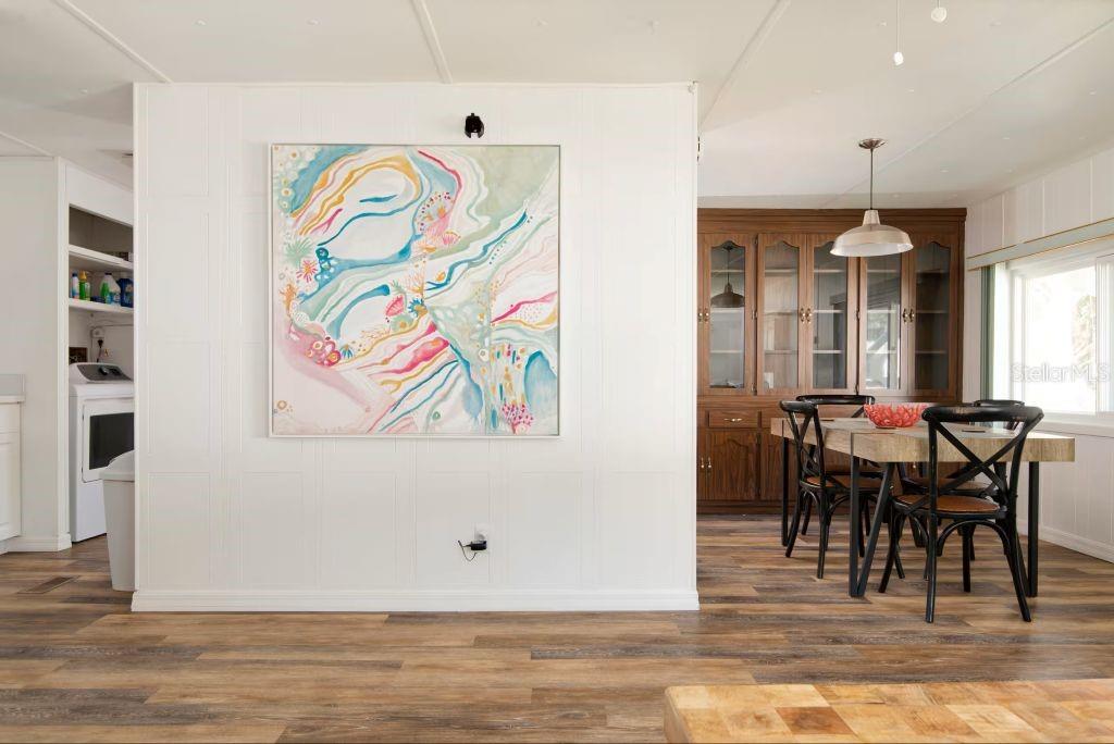 A dining area with a wooden hutch and a large abstract painting on a white wall — 8565 W DREW COURT, HOMOSASSA, FL