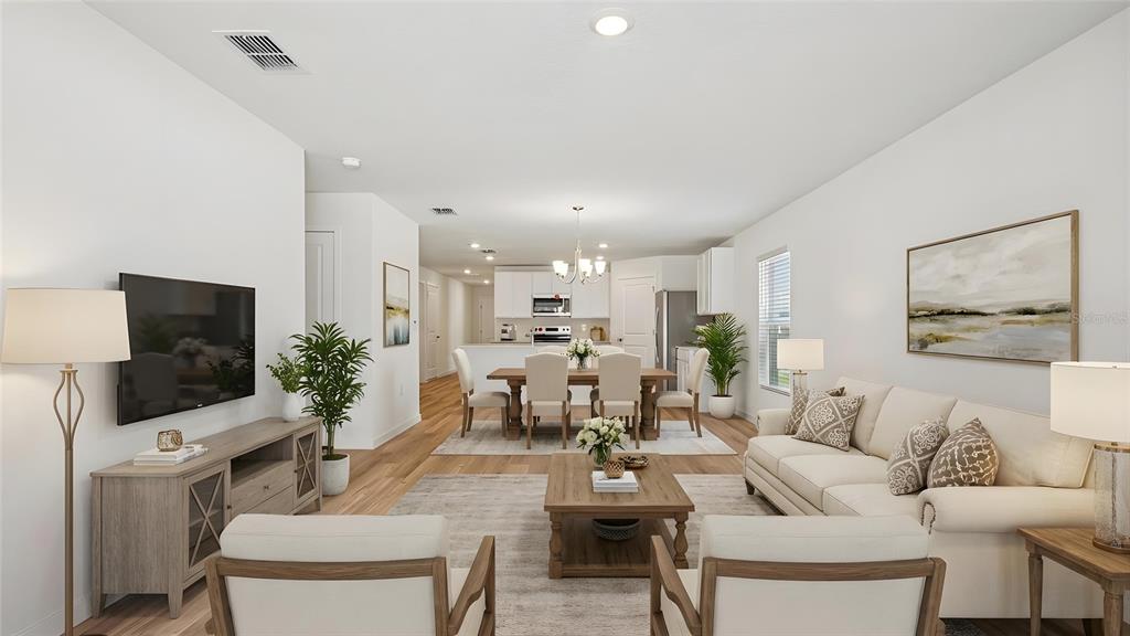 An open-concept living and dining area features light wood floors, white walls, and neutral furniture — 10157 SE 158TH LANE, SUMMERFIELD, FL