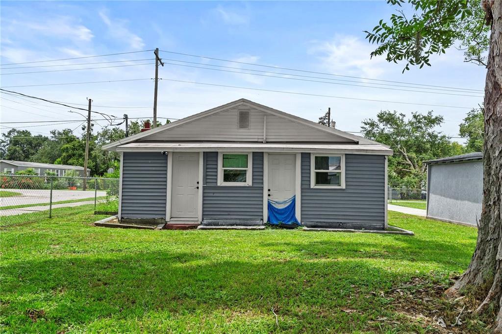 A gray, single-story detached building with two doors and two windows sits on a lawn — 204 PINE AVENUE, POLK CITY, FL
