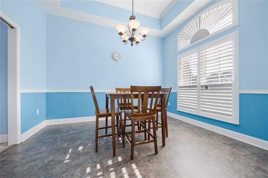 An empty room with light blue walls, gray tile flooring, and a large arched window — 254 SW NIGHTSHADE DRIVE, LAKE CITY, FL