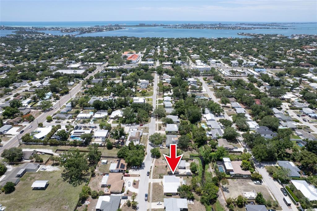 An aerial view shows a residential neighborhood with a red arrow pointing to a house — 2215 GROVE STREET, SARASOTA, FL