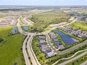 An aerial view shows a suburban neighborhood with houses, a roundabout, and several retention ponds — 8370 VELDA TRAIL, SARASOTA, FL