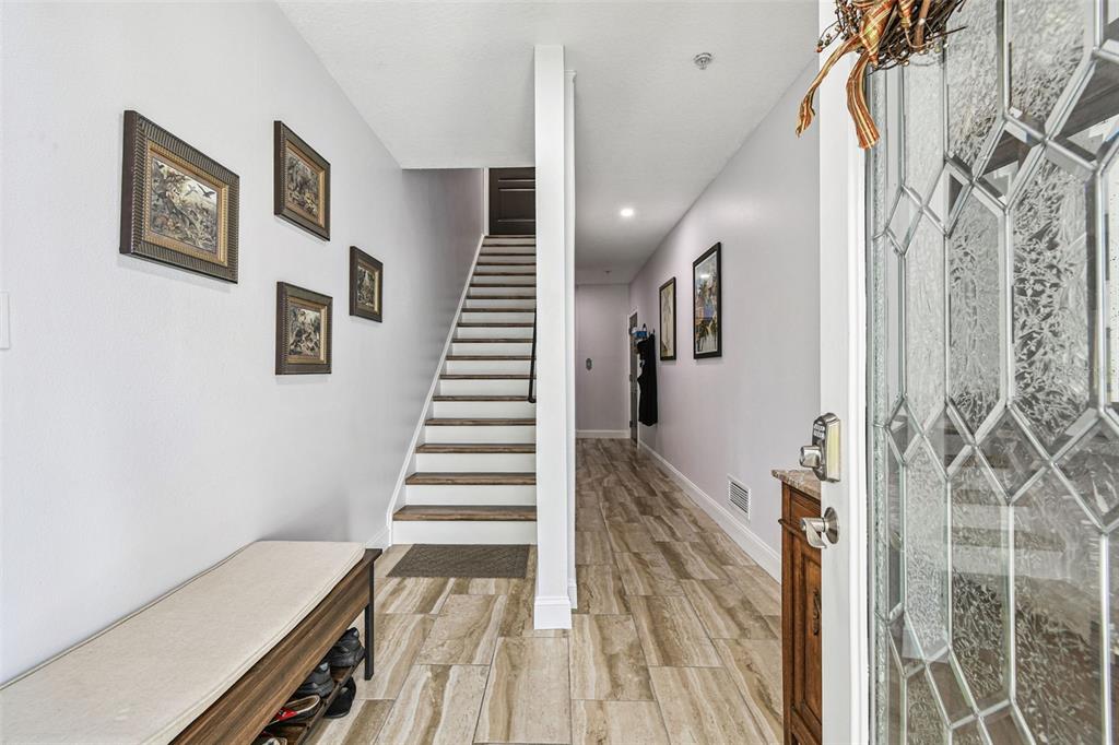 A covered porch features a small bistro set and a white front door with glass inserts — 6331 SUNSET BAY CIRCLE, APOLLO BEACH, FL