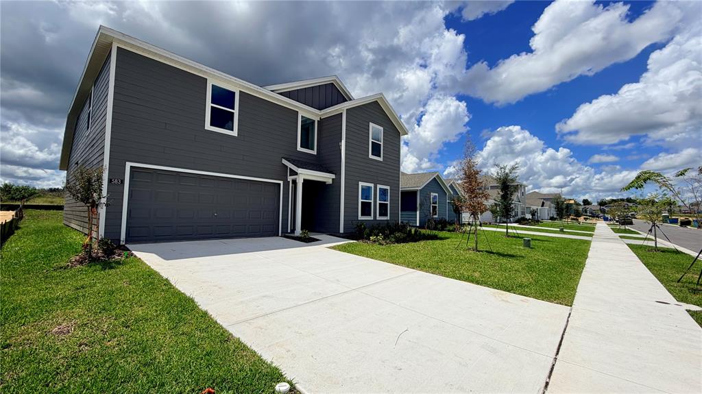 A two-story house with dark gray siding, a two-car garage, and a concrete driveway — 583 ARTEMIS STREET, LAKE WALES, FL