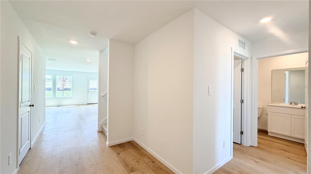 An interior view shows a hallway leading to a living area with a bathroom nearby — 583 ARTEMIS STREET, LAKE WALES, FL