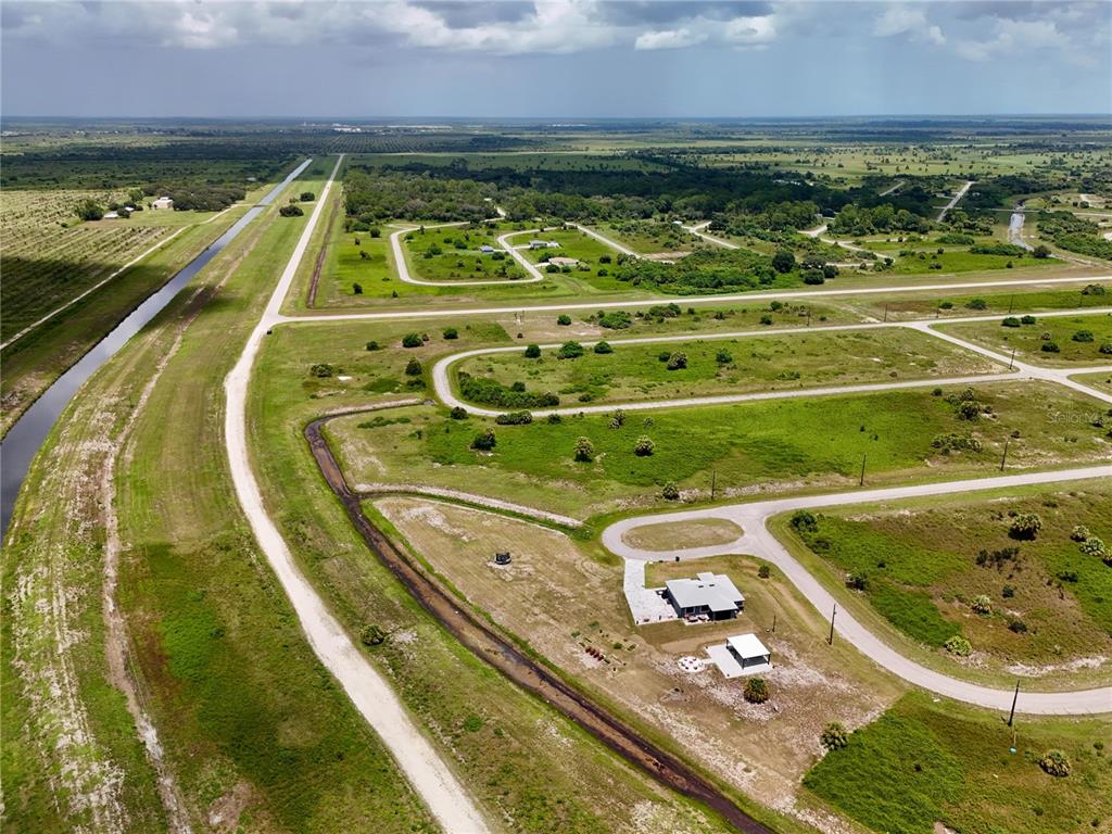 An aerial view shows a rural residential lot with a house and a drainage canal — 218 LYNBROOK LOOP, LABELLE, FL