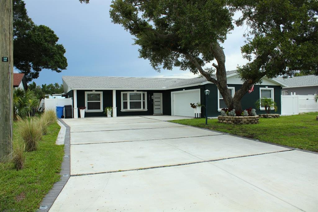 A single-story house with black exterior walls and a white trim sits behind a lawn — 5817 TAMPA SHORES BOULEVARD, TAMPA, FL
