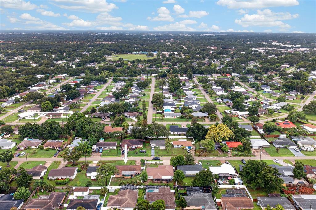 An aerial view shows a residential neighborhood with a white arrow pointing to a house — 4701 SPAHN STREET, SARASOTA, FL