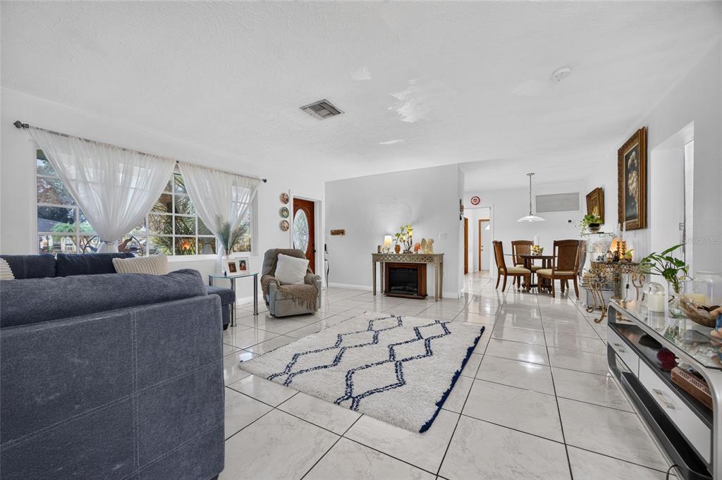 A living room with white tile floors, a blue sofa, and a white patterned rug — 4701 SPAHN STREET, SARASOTA, FL