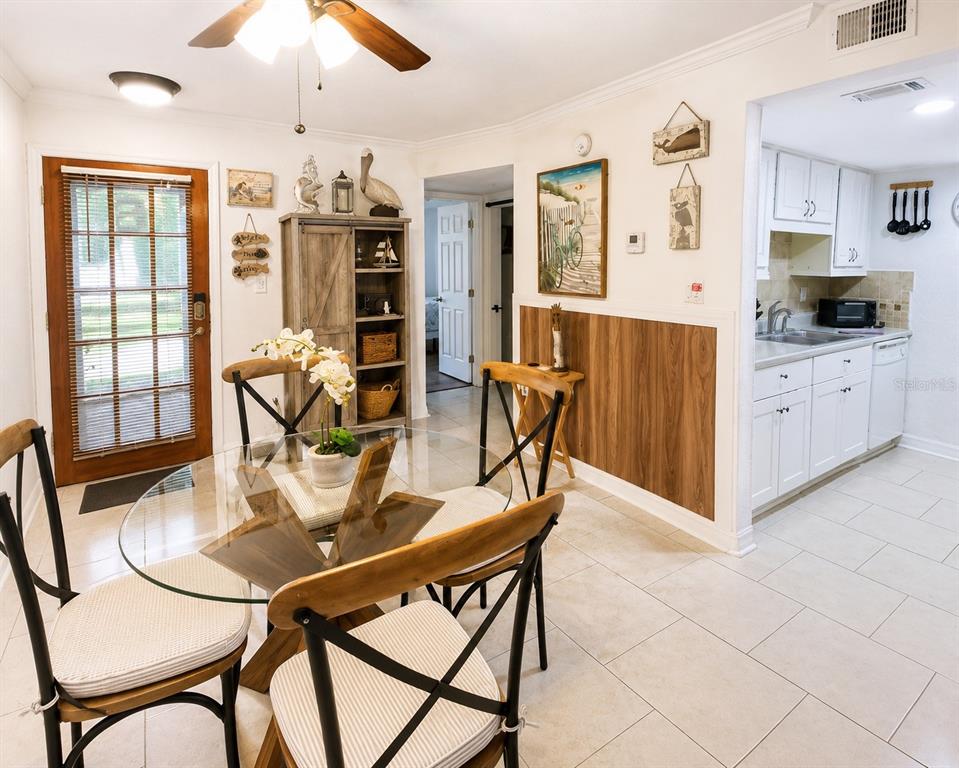 A living room features a brown sofa, two armchairs, a coffee table, and sliding glass doors — 3735 42ND WAY S UNIT E, ST PETERSBURG, FL