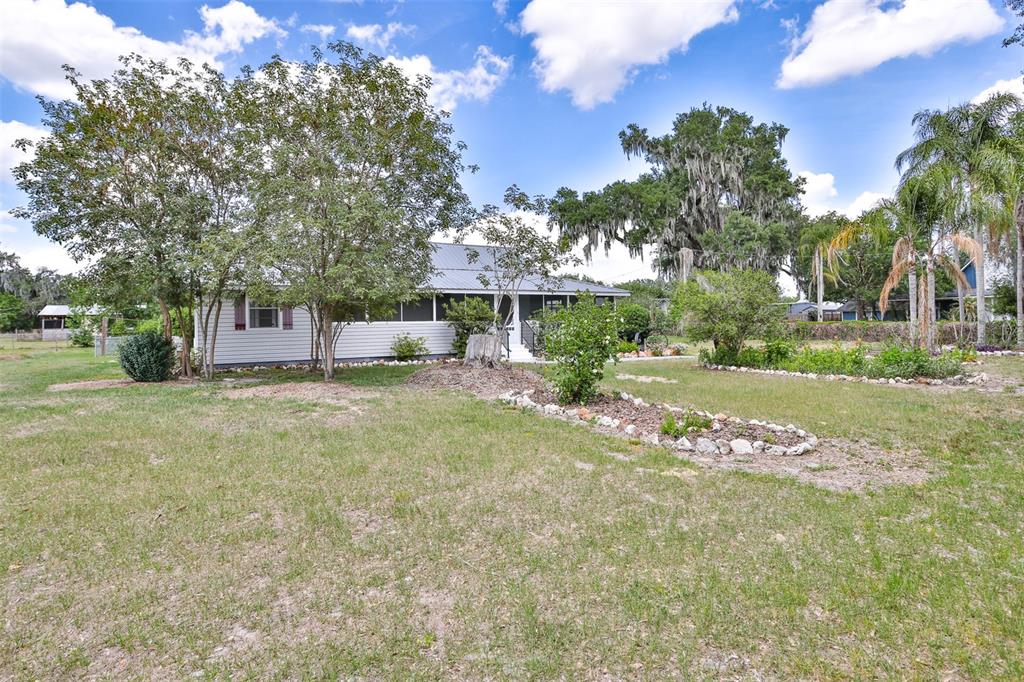 A single-story house with light siding and a metal roof sits on a grassy lot — 610 LYLE PARKWAY, BARTOW, FL