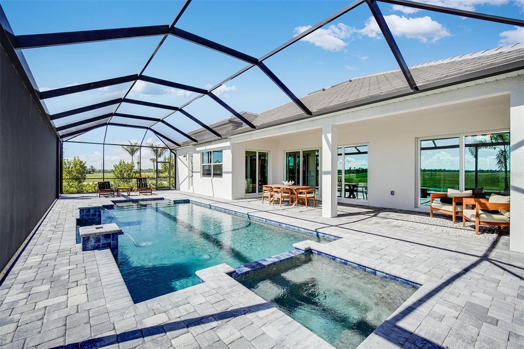 A screened-in patio features a swimming pool, a spa, and outdoor seating under a roof — 20009 TROUT TERRACE, LAKEWOOD RANCH, FL