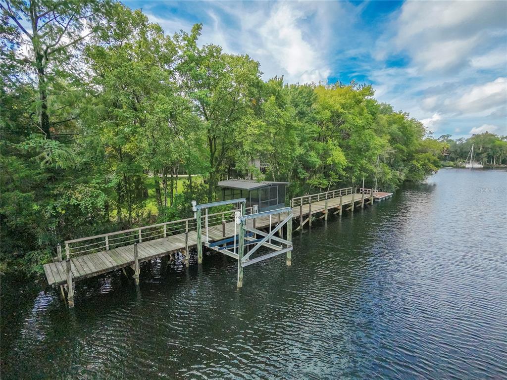 An aerial view of a wooden dock with a boat lift extending into a river — 11772 N RIVER SOUND PATH, INGLIS, FL